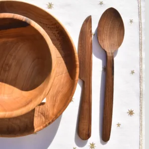Walnut wood spoon mixing food in pot on modern kitchen table