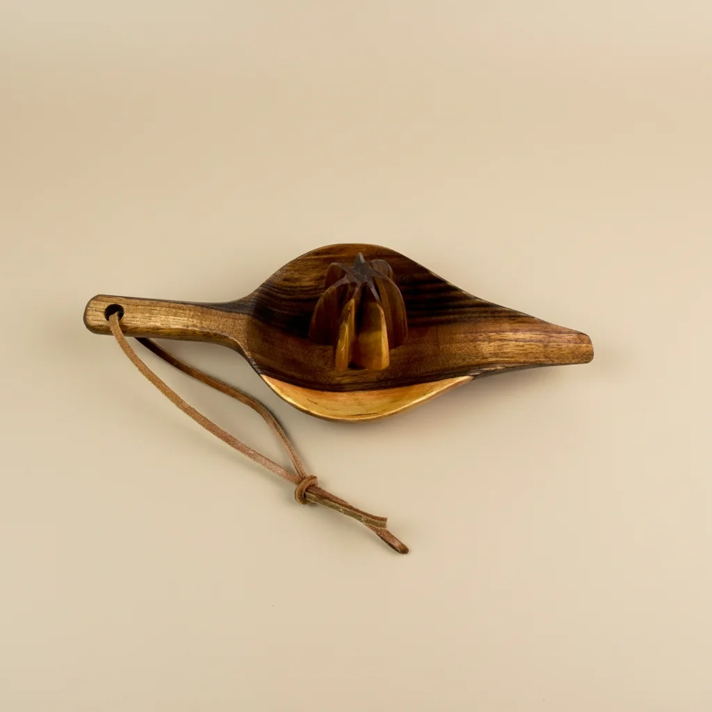 Manual walnut wood citrus juicer with ergonomic design and smooth finish on neutral background